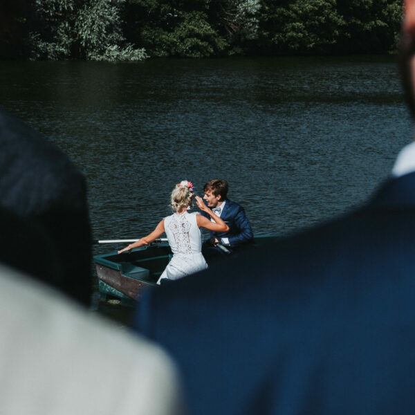 Un couple de mariés sur une barque au milieu d'un petit étang en Rhône-Alpes.