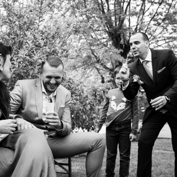Un marié qui s'amuse à faire des bulles avec ses amis lors du vin d'honneur, en Haute-Saône