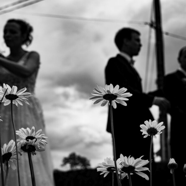 En Franche-Comté, des silhouettes de mariés derrière des fleurs, en noir et blanc