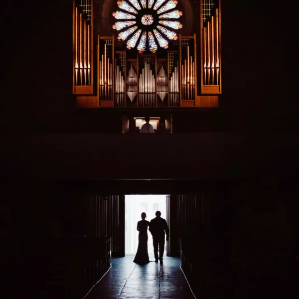 Une mariée qui entre dans une église pour la cérémonie de mariage avec son père à son bras.
