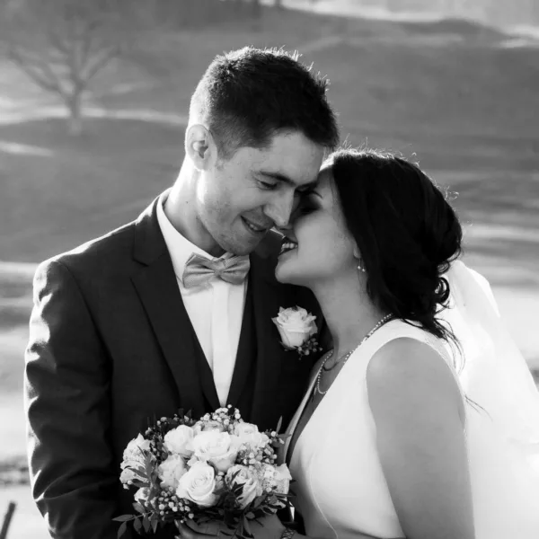 Couple de mariés qui s'embrassent avec un bouquet de fleurs dans la main de la mariée, dans le Territoire de Belfort